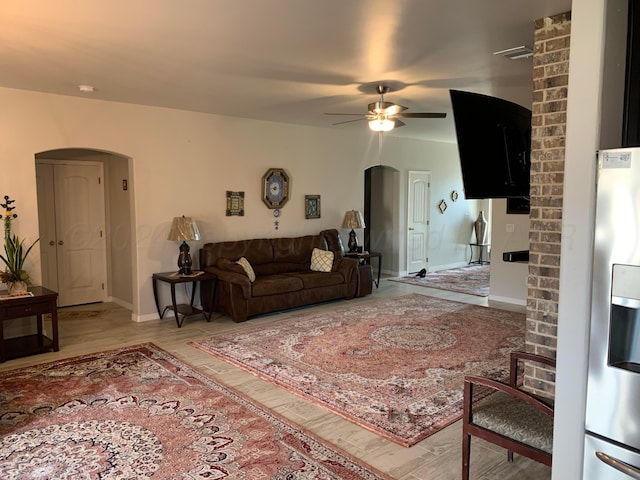 living room featuring wood-type flooring and ceiling fan