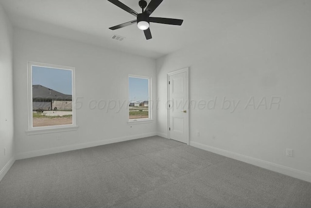 empty room with visible vents, baseboards, a ceiling fan, and carpet