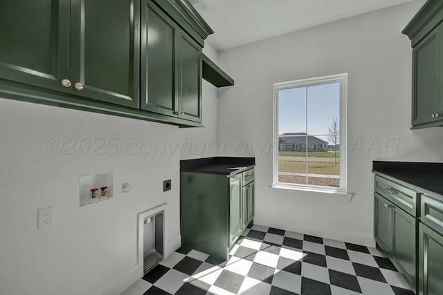 laundry room featuring dark floors, hookup for an electric dryer, washer hookup, and cabinet space