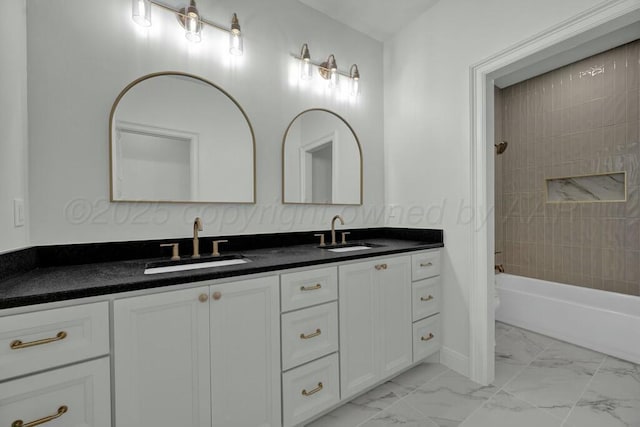 bathroom featuring a sink, double vanity, marble finish floor, and shower / bathtub combination