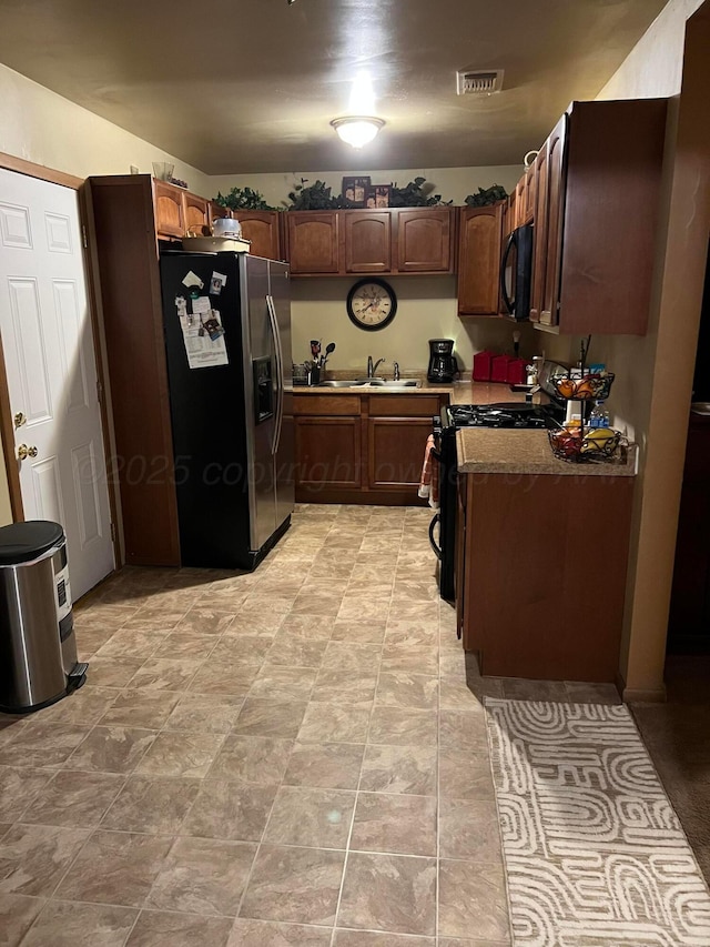 kitchen with black appliances, visible vents, and a sink