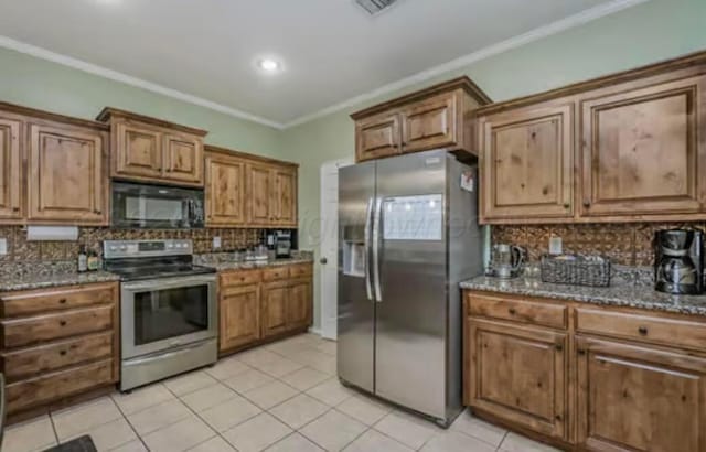 4014 Willow St, Amarillo, TX 79118 - kitchen featuring stainless steel appliances, tasteful backsplash, light tile patterned floors, brown cabinets, and dark stone countertops