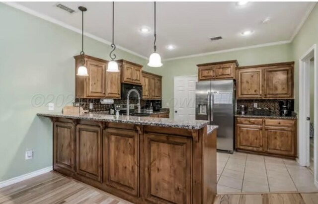4014 Willow St, Amarillo, TX 79118 - kitchen featuring stainless steel fridge with ice dispenser, a peninsula, decorative backsplash, brown cabinetry, and crown molding