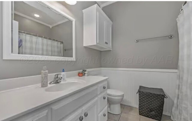4014 Willow St, Amarillo, TX 79118 - bathroom featuring vanity, toilet, tile patterned flooring, and a wainscoted wall