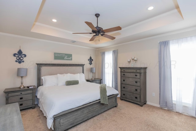bedroom featuring light carpet, crown molding, and a tray ceiling