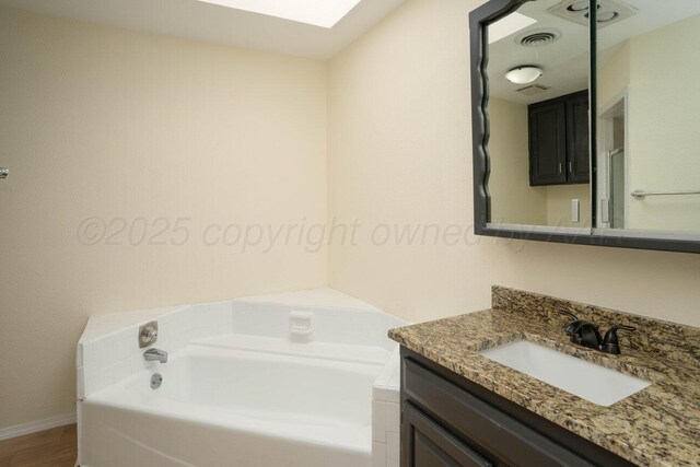 5207 While A Way Rd, Amarillo, TX 79109 - bathroom with vanity, a garden tub, a skylight, and wood finished floors