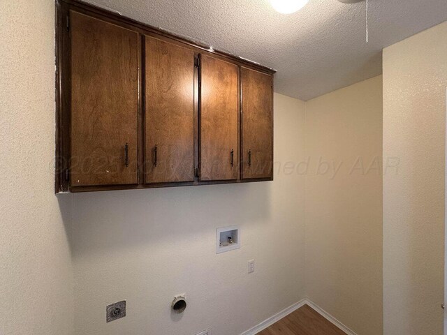 5207 While A Way Rd, Amarillo, TX 79109 - laundry room featuring cabinet space, hookup for an electric dryer, washer hookup, a textured ceiling, and wood finished floors