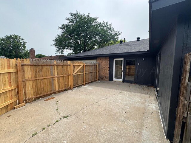 5207 While A Way Rd, Amarillo, TX 79109 - back of property featuring a chimney, a patio, roof with shingles, and brick siding