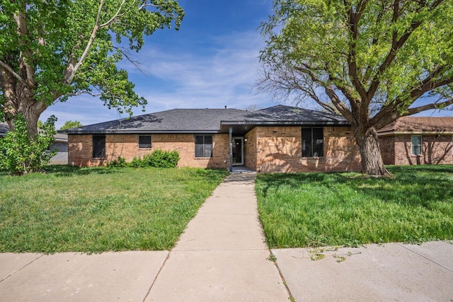 5207 While A Way Rd, Amarillo, TX 79109 - ranch-style house with brick siding, a front yard, and a shingled roof