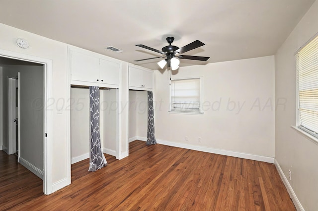 1603 SW 35th Ave, Amarillo, TX 79109 - unfurnished bedroom with dark wood-style floors, baseboards, two closets, and a ceiling fan