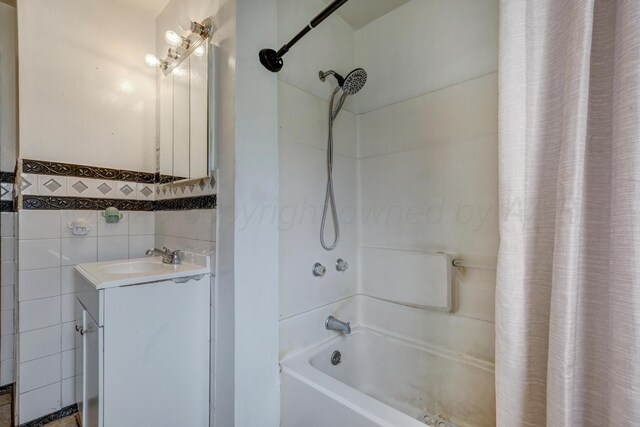 823 Ave N, Sunray, TX 79086 - bathroom featuring shower / tub combo with curtain, tile walls, vanity, and wainscoting