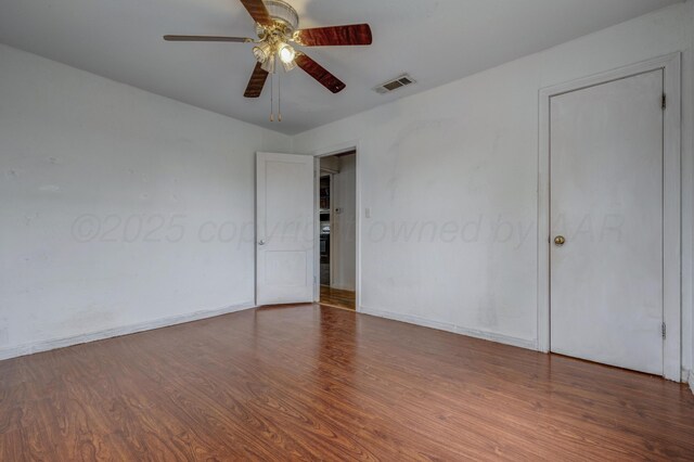 823 Ave N, Sunray, TX 79086 - unfurnished bedroom with wood finished floors, baseboards, and a ceiling fan