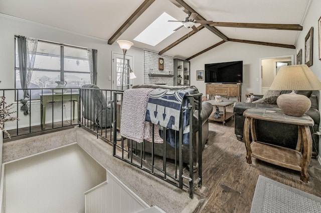 living room featuring lofted ceiling with skylight, a ceiling fan, and wood finished floors