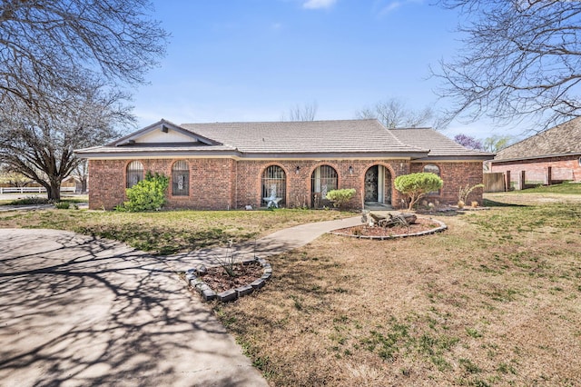 single story home featuring a front lawn and brick siding
