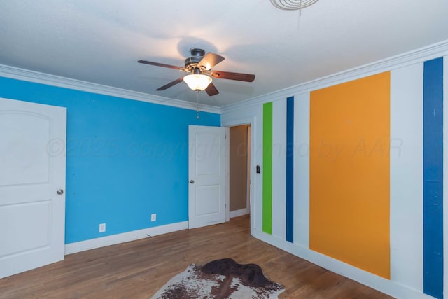 unfurnished bedroom with ceiling fan, ornamental molding, and hardwood / wood-style floors