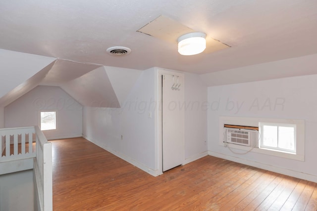 bonus room featuring wood-type flooring, vaulted ceiling, and cooling unit