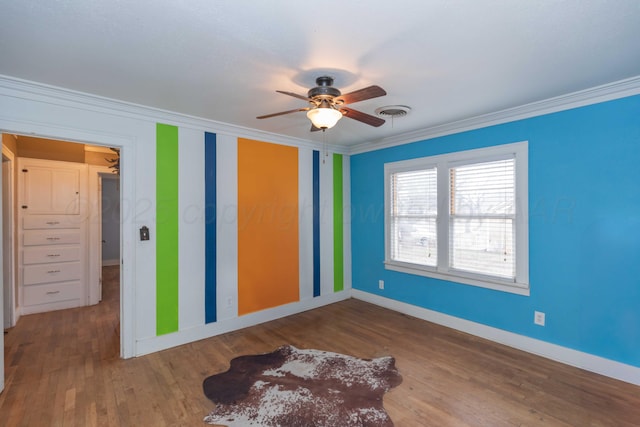 unfurnished bedroom featuring crown molding, ceiling fan, and hardwood / wood-style flooring