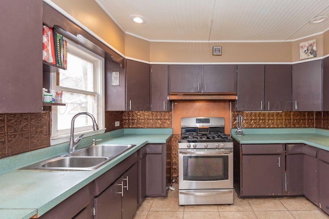 kitchen featuring sink, backsplash, light tile patterned floors, gas range, and dark brown cabinets