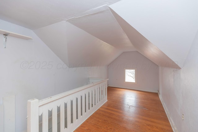 additional living space with lofted ceiling and hardwood / wood-style floors