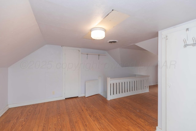 bonus room featuring vaulted ceiling and hardwood / wood-style floors