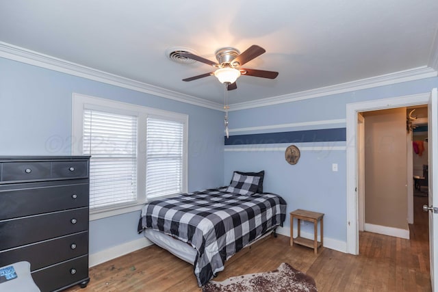 bedroom with dark hardwood / wood-style flooring, crown molding, and ceiling fan