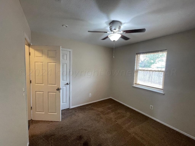 carpeted empty room featuring ceiling fan and a textured ceiling