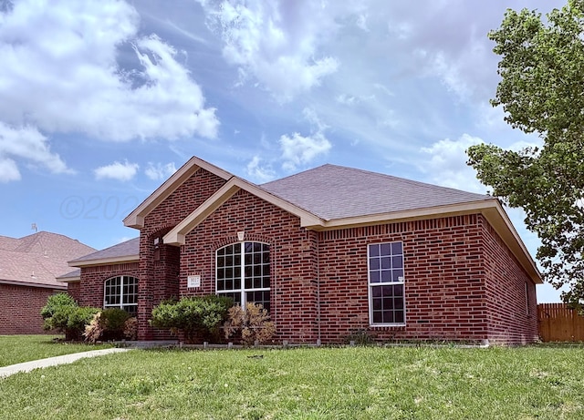9317 Shylana Ave, Amarillo, TX 79119 - view of front of house with brick siding, a shingled roof, and a front lawn