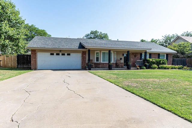 ranch-style home featuring a porch, a front yard, and a garage