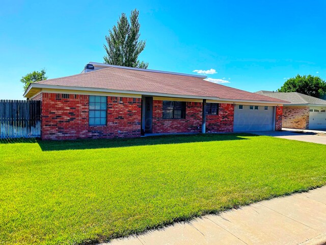 ranch-style house with a garage and a front lawn