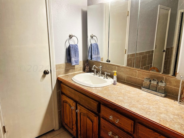 bathroom with tile patterned flooring, vanity, and decorative backsplash