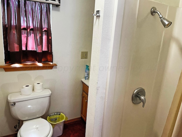 bathroom with toilet, vanity, and walk in shower