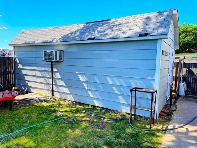 view of outdoor structure featuring a wall mounted AC and a yard