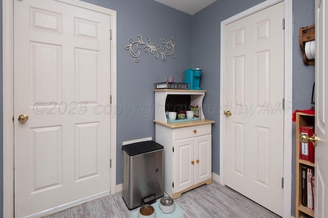 interior space with baseboards and light wood finished floors