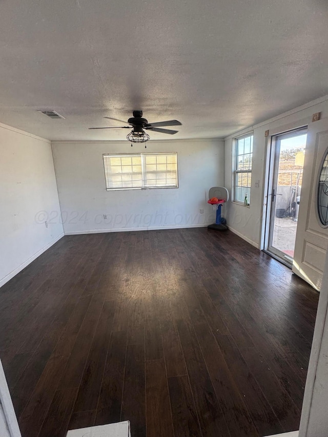 interior space featuring ceiling fan, dark wood-type flooring, and a textured ceiling