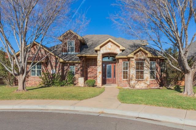 view of front of house with a front yard, stone siding, and brick siding