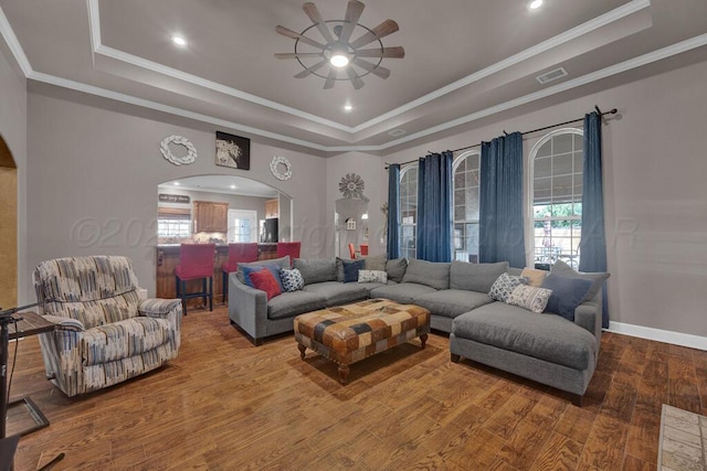 6905 Spring Cherry Ln, Amarillo, TX 79124 - living room featuring arched walkways, a raised ceiling, a ceiling fan, wood finished floors, and crown molding