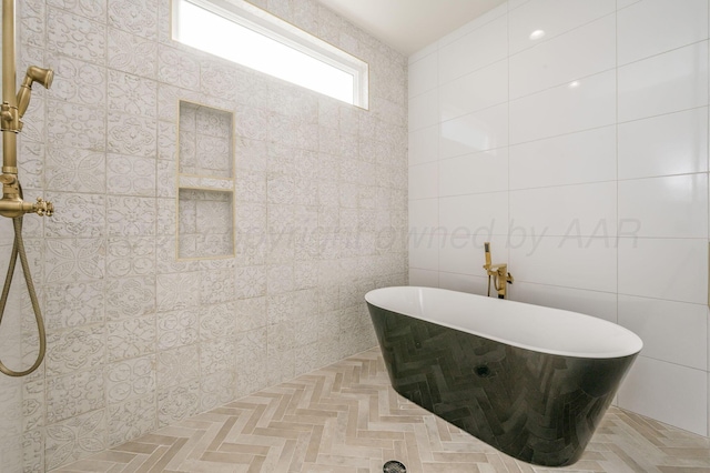 full bath featuring a soaking tub and tile walls