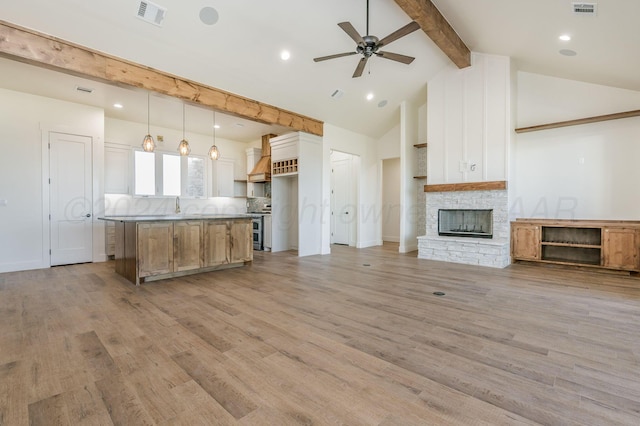 kitchen featuring visible vents, white cabinets, open floor plan, stainless steel range, and decorative light fixtures