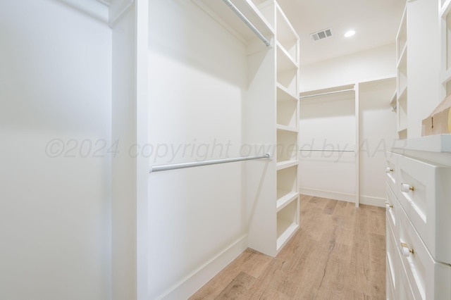 walk in closet with light wood-type flooring and visible vents