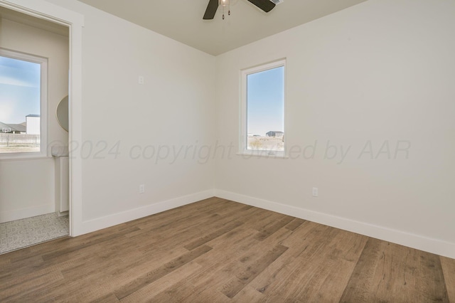 spare room with ceiling fan, baseboards, and wood finished floors