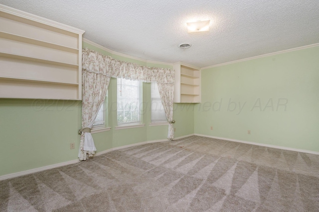 empty room with a textured ceiling, carpet floors, and ornamental molding