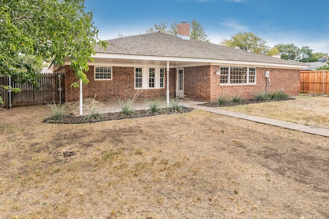 ranch-style home with a front yard and a patio