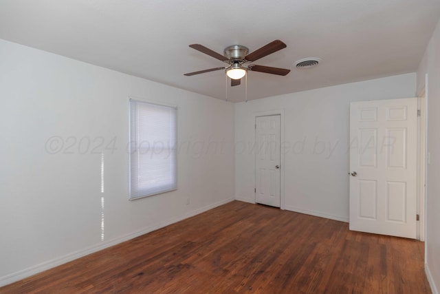 empty room featuring dark hardwood / wood-style flooring and ceiling fan