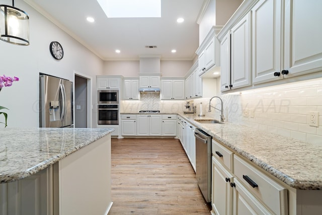7323 Parkway Dr, Amarillo, TX 79119 - kitchen with stainless steel appliances, a sink, a skylight, crown molding, and light wood-type flooring