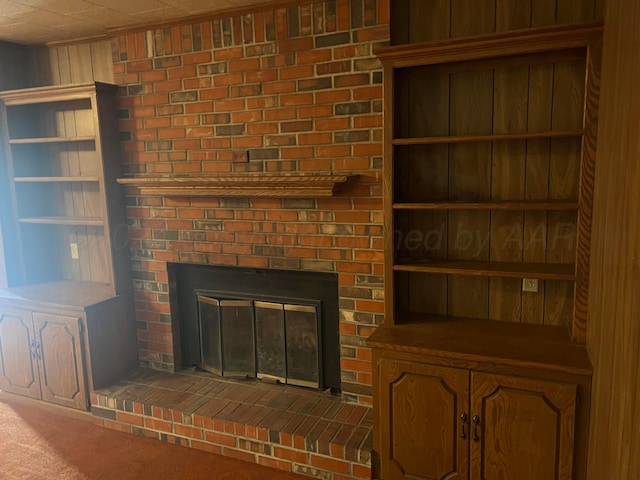 room details with carpet flooring, wooden walls, and a brick fireplace