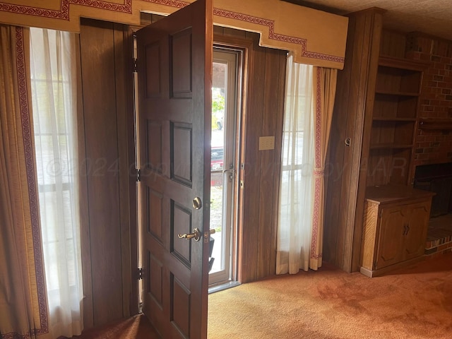 carpeted foyer featuring a fireplace and plenty of natural light