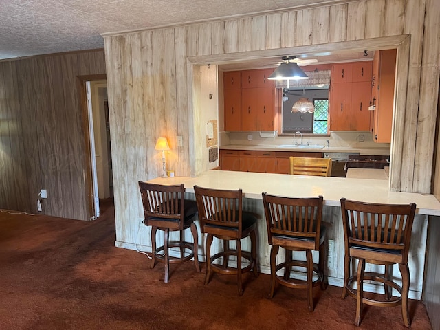 kitchen with dark carpet and wooden walls