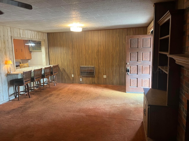 living room featuring carpet flooring, an AC wall unit, wooden walls, and heating unit