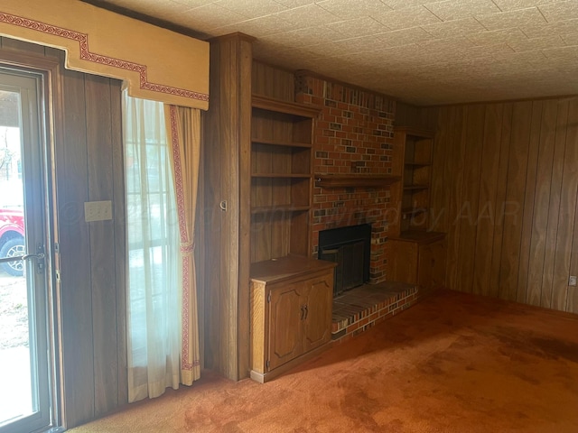 unfurnished living room with wooden walls, light colored carpet, and a healthy amount of sunlight