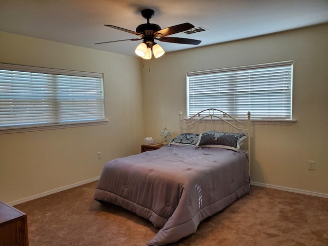 carpeted bedroom with multiple windows and ceiling fan